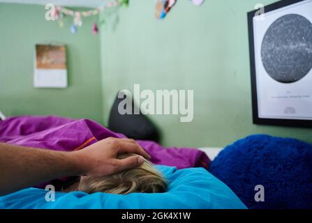 Berlin, Germany. 11th Sep, 2021. A father puts his hand on the head of a child lying in bed. Credit: Annette Riedl/dpa/Ģ����ý Live News Stock Photo