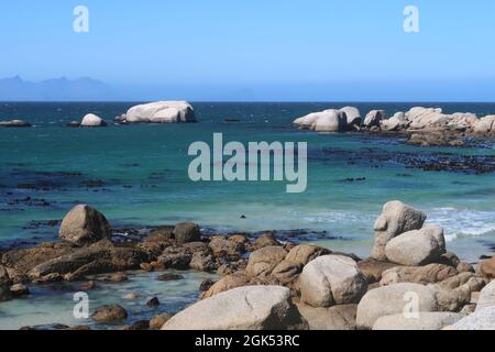 Scenic turquoise Indian ocean water along sandy beach with large granite boulders near Simons's town, on the Cape Peninsula, Cape Town, South africa Stock Photo