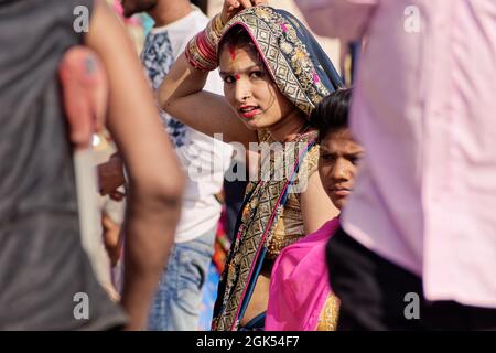 Orchha, Madhya Pradesh, India - March 2019: An Indian woman wearing a colorful sari in a crowded market during a festival. Stock Photo