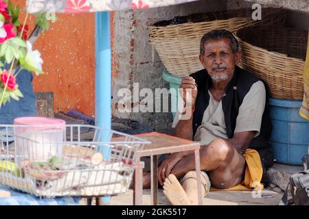 Orchha, Madhya Pradesh, India - March 2019: An Indian male street vendor sitting alone idle in his roadside stall. Stock Photo