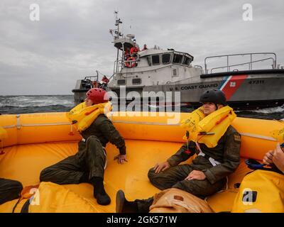 Airmen from the 436th Operational Support Squadron survival, evasion, resistance and escape flight sit in a 25-man survival raft near Coast Guard Station Indian River Inlet, Delaware, Aug. 4, 2021. Exercise Castaway is an interagency training exercise that brought Airmen from Dover AFB and two coast guard stations, Coast Guard Air Station Atlantic City, New Jersey, and Coast Guard Station Indian River Inlet, Delaware, together to train local search and rescue procedures. Stock Photo