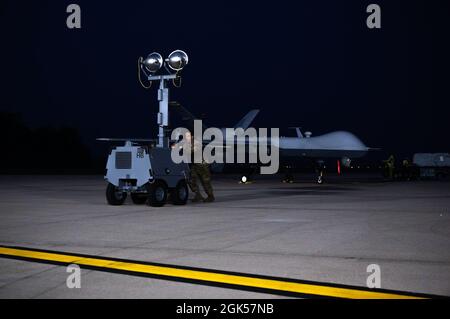 U.S. Air Force Senior Airman Eric Fullmer, a crew chief for the 214th Maintenance Squadron, Arizona Air National Guard, moves light equipment off of the flightline prior to a MQ-9 Reaper launch during Northern Strike 21 at Alpena Combat Readiness Training Center, Michigan, Aug. 5, 2021. Northern Strike is a National Guard Bureau-sponsored exercise that is a tailored readiness producer that has brought together 5,100 participants from various states and countries at the National All-Domain Warfighting Center. Stock Photo