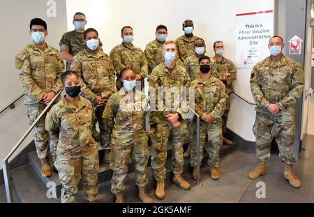 Service members from New York State Military forces assigned to JTF South pose for a group photo at the vaccine Point of Distribution (POD) site located at Stony Brook University, LI, NY, on Aug 5th, 2021. New York State military forces continue to support several vaccination sites across the state as part of the State's ongoing efforts to vaccinate as many New Yorkers as possible. Stock Photo