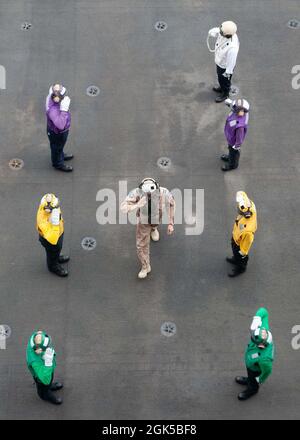 210806-N-JK118-1093 ARABIAN SEA (Aug. 6, 2021) – Royal Australian Air Force Air Commodore Nathan Christie, Combined Air Operations Center (CAOC) director, salutes side boys on the flight deck of aircraft carrier USS Ronald Reagan (CVN 76) during a visit to the ship in the Arabian Sea, Aug. 6. Ronald Reagan is deployed to the U.S. 5th Fleet area of operations in support of naval operations to ensure maritime stability and security in the Central Region, connecting the Mediterranean and Pacific through the western Indian Ocean and three strategic choke points. Stock Photo