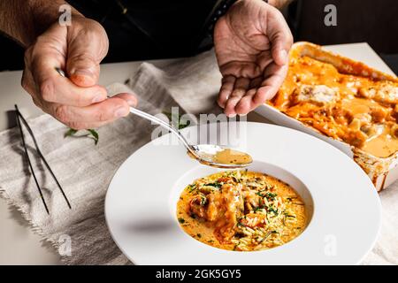 Authentic Spanish paella with cod and mussels. Traditional Mediterranean seafood dish. The chef prepares the dish. Restaurant dish serving. Close-up. Stock Photo