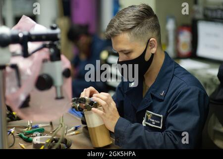 210808-N-TY704-1268 PACIFIC OCEAN (August 8, 2021) Aviation Electrician’s Mate 3rd Class Benjamin Staggs, a native of Kalispell, Montana, performs maintenance on a pylon cable in the Aviation Intermediate Maintenance Department workshop of Nimitz-class aircraft carrier USS Carl Vinson (CVN 70), August 8, 2021. The Carl Vinson Carrier Strike Group (CVCSG), led by Carrier Strike Group (CSG) 1, is deployed in support of global maritime security operations. Stock Photo