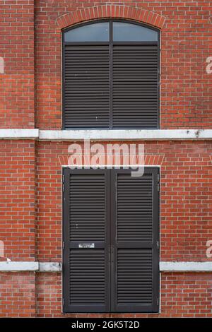 Red brick wall facade with metal windows Stock Photo