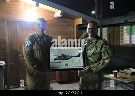 Task Force Wolfpack commander Lt. Col. James Snowden is presented a gift by Task Force Griffon outgoing commander Lt. Col. Francesco Colucei after a Transfer of Authority ceremony at Erbil Air Base, Iraq. Task Force Griffon, from the 5th Regiment of the Italian Army, is a detachment of three NH-90 medium lift helicopters, aircrew and support personnel based at Erbil Air Base, Iraq, under tactical control (TACON) of Task Force Phoenix. Lt. Col. Francesco Colucei turned over the unit to Lt. Col. Mario Giorgi. Stock Photo