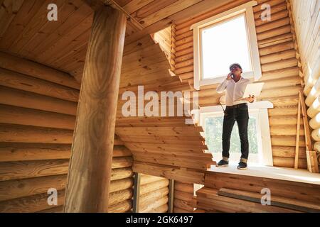 Person with laptop taking phone call on staircase Stock Photo