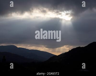 A shaft of sunlight breaking through clouds over Ambleside, Lake District, UK.
