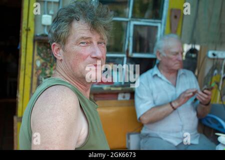 An adult son on the background of an elderly old man's father. Father and son. Stock Photo
