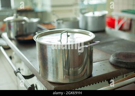 Large pot for cooking. Kitchen utensils in the dining room. Stainless steel water tank. Dishes in the kitchen. Stock Photo