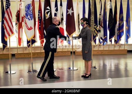 Brig. Gen. Anthony McQueen, Commanding General of USAMRDC and Fort Detrick (left), shakes hands with Dr. Ana-Claire Meyer prior to her Senior Leadership induction ceremony on Friday, August 13, at the Fort Detrick Auditorium. (Photo Credit: Ramin A. Khalili, USAMRDC Public Affairs) Stock Photo