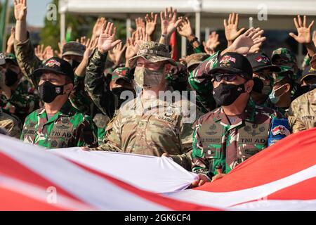 Brigadier Gen. Joseph Ryan, commanding general of the 25th Infantry Division, and Tentara Nasional Indonesia (TNI-AD Indonesia Armed Forces) wave a United States and Indonesian Flag together during the closing ceremony for Garuda Shield 21 at Baturaja Training Area, on August 14, 2021. Garuda Shield 21 is a two-week joint-exercise between the United States Army and (TNI-AD Indonesia Armed Forces). The purpose of this joint-exercise is to enhance and enrich the jungle warfare ability of both the U.S. Army and Indonesian Army. Stock Photo