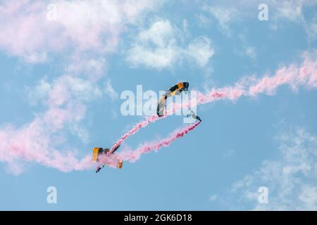 Soldiers from the U.S. Army Parachute Team perform a parachute demonstration at the Airborne and Special Operations Museum in Fayetteville, North Carolina, 14 Aug. 2021. The event was held in celebration of National Airborne Day. Stock Photo