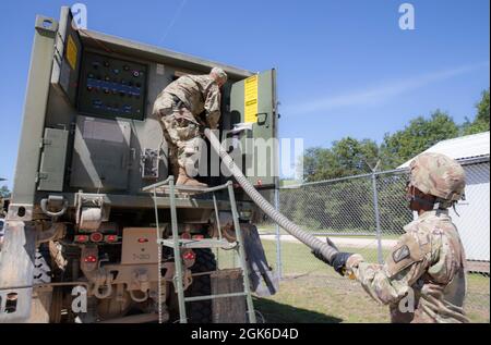 Pfc. Michael Landry, a water treatment specialist, right, and Spc. Calvin McWhorter, a wheeled vehicle mechanic, both with the 303rd Quartermaster Company, based out of Lake Charles, Louisiana, prepare to fill a water buffalo during Combat Support Training Exercise (CSTX) at Fort McCoy, Wisconsin, Aug. 14, 2021. CSTX prepares Soldiers through scenarios that simulate deployed conflict against a near peer adversary. Proper hydration contributes to Soldier readiness by improving resistance to heat related injuries. Stock Photo