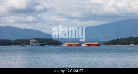 Industrial Tugboat pulling Seaspan Containers Stock Photo