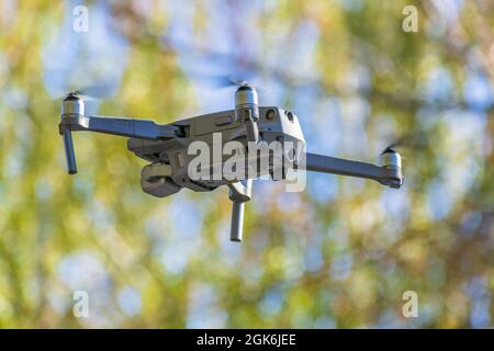 Modern model of quadrocopter for photo and video shooting flies in abstract blue-green background Stock Photo