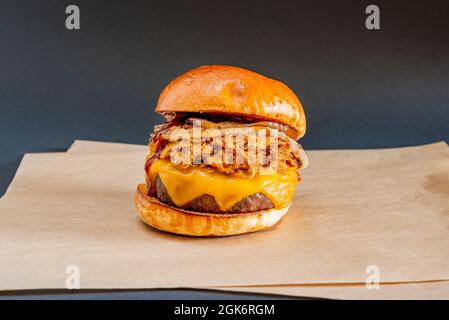 beef burger with double beef shredded stewed chicken, white onion rings, lots of melted cheddar cheese and ketchup and bulk tomato Stock Photo
