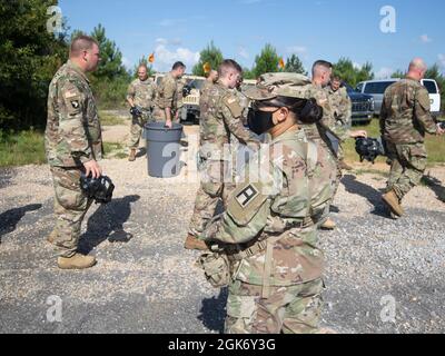 An Observer, Coach/Trainer assigned to the 177th Armored Brigade ushers Soldiers assigned to the 447th Military Police Company toward a designated recuperation area during CBRN training as part of a Mobilization Exercise, Aug. 19, 2021 at Camp Shelby, MS. Stock Photo