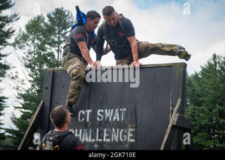 Tech. Sgt. Leo Otero (left) helps Staff Sgt. Adam Roach climb over a wall during the physical training portion of the Connecticut SWAT Challenge in West Hartford, Connecticut, Aug. 19, 2021. The competition brings together tactical operators from across the nation to train SWAT weapons tactics, movements, and physical fitness. Stock Photo