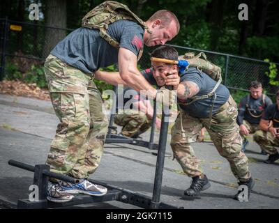 Tech. Sgt. Leo Otero, 103rd Security Forces Squadron, pushes a sled weighted by Staff Sgt. Collin Gallagher-Paeth during the physical training portion of the Connecticut SWAT Challenge in West Hartford, Connecticut, Aug. 19, 2021. The competition brings together tactical operators from across the nation to train SWAT weapons tactics, movements, and physical fitness. Stock Photo