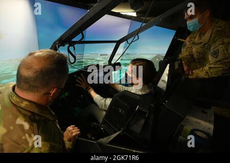 U.S. Rep. Nancy Mace from Charleston, South Carolina receives an in-flight demonstration of the AH-64 Apache helicopter simulator at the South Carolina Army National Guard’s aviation facility located at McEntire Joint National Guard Base, South Carolina Aug. 19, 2021. U.S. Army Col. John McElveen, 59th Troop Command commander, foreground, and U.S. Army Chief Warrant Officer 4 Joel Gooch, 1-151st Attack Reconnaissance Battalion pilot, offer instruction on the flight characteristics of the Apache while Mace operates the flight controls. The purpose of her visit is to meet with South Carolina Nat Stock Photo
