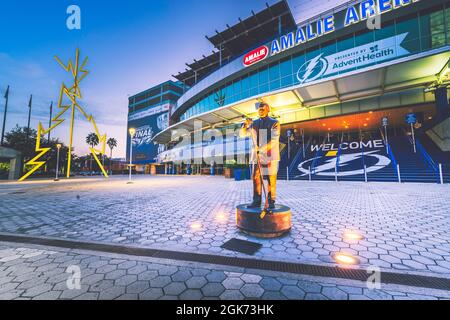 Tampa, FL—Sept 13, 2021; statue of Phil Esposito stands in front of Amalie Arena home to Tampa Bay Lightning NHL franchise at sunrise Stock Photo