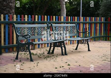 Vintage Italian style garden furniture set up on a terrace next to a villa. Bright red flowers in the front. . High quality photo Stock Photo