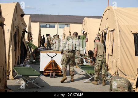 U.S. Army Soldiers from Special Troops Battalion, 21st Theater Sustainment Command, help setup cots at Ramstein Air Base, Germany, August 21, 2021. The 21st Theater Sustainment Command supports the Department of State in the transportation, housing, and sustainment of U.S. Citizens, Special Immigrant Visa applicants, and other at-risk Afghans who are being evacuated from Afghanistan. Stock Photo