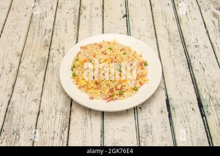 Three delights rice with diced ham, omelette, green peas and carrots on a white plate Stock Photo