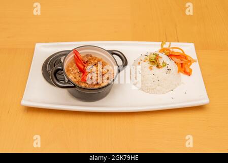 small black pie with Filipino bicol express stew with white rice and vegetables Stock Photo