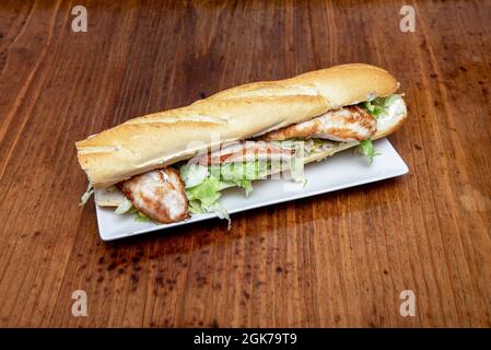 Huge sandwich of chicken on baguette bread typical of Spanish restaurant Stock Photo