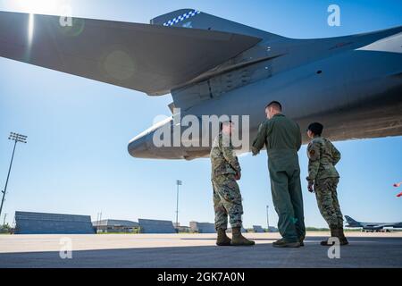 Lt. Col. Nathan Jenkins, 9th Bomb Squadron commander, center, briefs Maj. Gen. Andrew Gebara, 8th Air Force and Joint-Global Strike Operations Center commander, left, and Chief Master Sgt. Melvina Smith, 8th Air Force command chief and J-GSOC senior enlisted leader, while observing a B-1B Lancer on the flightline at Dyess Air Force Base, Texas, Aug. 23, 2021. During his visit, Gebara received several briefings on the B-1’s mission set and combat capabilities. Stock Photo