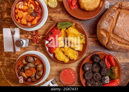 set of dishes with recipes of atavica Spanish food with snails, cod battered with fried peppers, cayenne, tripe, Spanish omelette, fried rice black pu Stock Photo