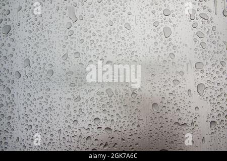 Abstract art texture background of raindrops on shiny brushed stainless steel metal surface of old retro vintage car. Drops of rainwater on a piece of polished industrial equipment Stock Photo