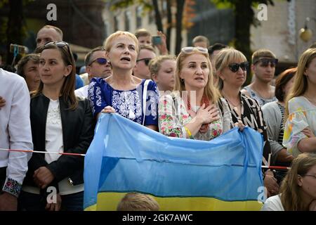 Ukrainian women sing along to their national anthem during the Independence Day parade at Kyiv, Ukraine, Aug. 24, 2021. During the celebration there was an aircraft flyover and a parade of military units, vehicles and bands moving past the Maidan, to celebrate 30 years of independence. Stock Photo