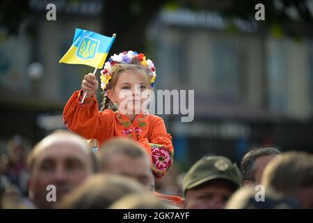 A Ukrainian girl waves a national flag during the Independence Day parade at Kyiv, Ukraine, Aug. 24, 2021. Independence Day is the main state holiday in modern Ukraine, celebrated in commemoration of the Declaration of Independence in 1991. Stock Photo