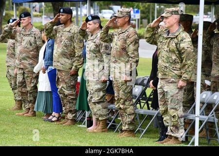 From right to left, the 7th Army Training Command commander U.S. Army Brig. Gen. Joseph E. Hilbert, the 7ATC senior enlisted adviser Command Sgt. Maj. Mark A. Morgan, the 41st Field Artillery Brigade commander U.S. Army Col. Daniel G. Miller, the 1st Battalion, 6th Field Artillery Regiment outgoing commander U.S. Army Lt. Col. Angel M. Llompart-Monge  and the 1-6 FAR senior enlisted advisor U.S. Army Command Sgt. Maj. David P. Cecil salute to the national anthem during the regiment’s change of command ceremony at the Tower Barracks parade field, Grafenwoehr, Germany, Aug. 24, 2021. Stock Photo