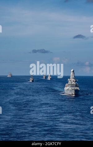 PHILIPPINE SEA (Aug. 24, 2021) From left to right, USS New Orleans (LPD 18), Royal Navy frigate HMS Kent (F 78), USS The Sullivans (DDG 68), Royal Netherlands Navy frigate HNLMS Evertsen (F 805), and Royal Navy destroyer HMS Defender (D 36) trail the forward-deployed amphibious assault ship USS America (LHA 6) during a photo exercise. America, flagship of the America Expeditionary Strike Group, along with the 31st MEU, is operating in the U.S. 7th Fleet area of responsibility to enhance interoperability with allies and partners and serve as a ready response force to defend peace and stability Stock Photo