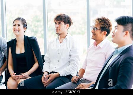 Close-up of businesswoman laughing and having fun listening to presentation and seminar alongside with male business coworker Stock Photo