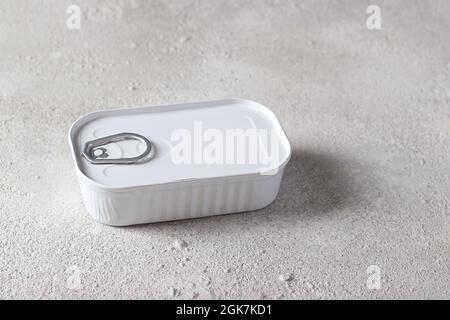 Cod liver in an white tin can on light gray background. Horizontal format. Stock Photo