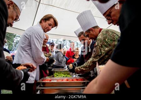 Battle Group Poland's commanders and Orzysz government officials assist Polish celebrity chef, Karol Okrasa, make fish burgers for Polish citizens during a festival at Orzysz, Poland, August 27, 2021. Battle Group Poland's leaders joined the local community to celebrate the Days of Orzysz, strengthening our partnership. Stock Photo