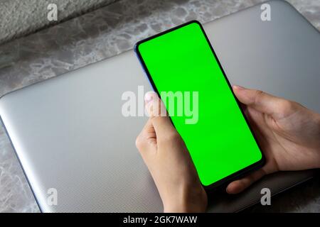 Mockup image of hand holding green screen mobile phone. Top view, copy space. Stock Photo