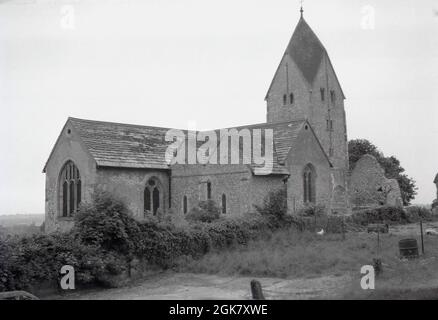 1962, historical view from this era of St Mary's church at Sompting, Littlehampton, West Sussex, England, UK. 1962, The flint built church building, with its saxon tower, was listed as Grade I by English Heritage in 1954, because of it's exceptional historical importance, particualry the Rhenish helm on the church tower, with its four-sided pyramid-style gabled cap very unusual in England. Stock Photo