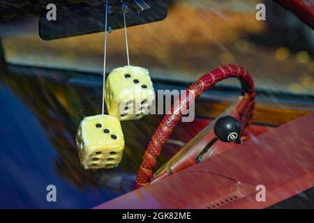 Furry dice hanging from car rear view mirror Stock Photo