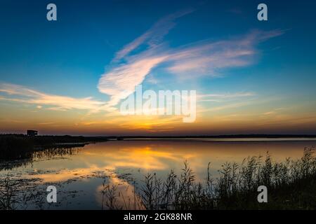 Dramatic Cloudscape with Symmetry Reflections on the Water above the Lake at Sunrise Stock Photo