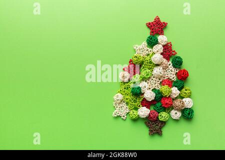 Christmas tree made from colored handmade ball decoration on colored background, view from above. New Year minimal concept with copy space. Stock Photo