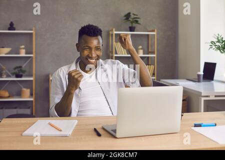 Portrait of excited happy African American man who received good news or positive response. Stock Photo