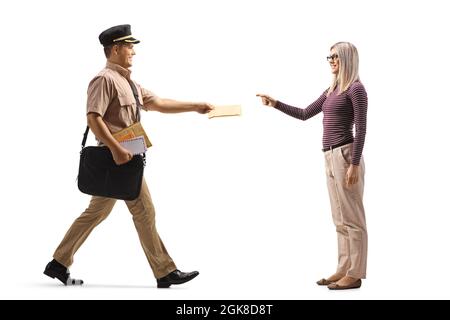 Full length profile shot of a mailman giving a letter to a young woman isolated on white background Stock Photo